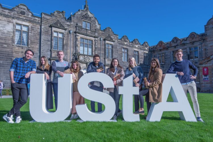 Students standing behind a UStA Ssign in St Salvators quad.